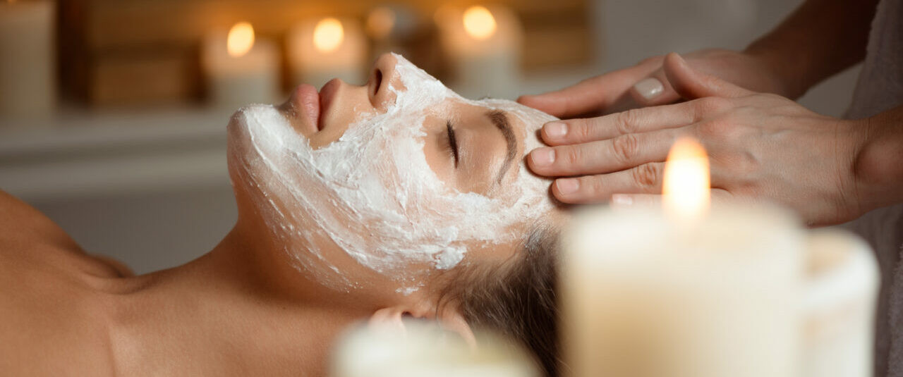 Young beautiful girl in mask for face relaxing in spa salon.